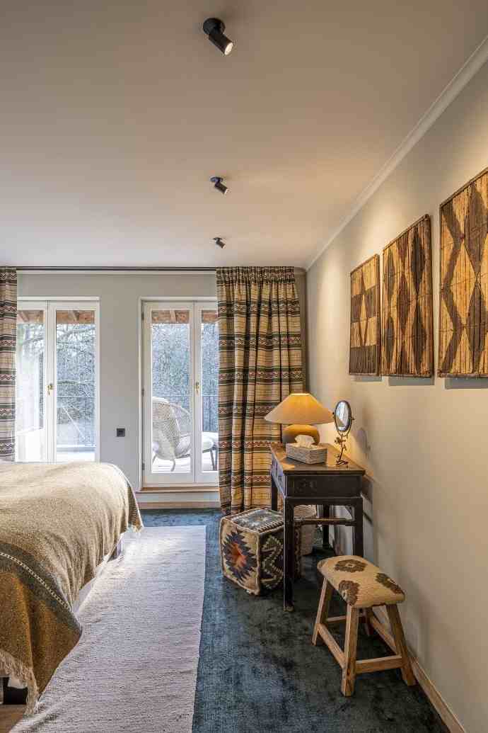 Chambre accueillante avec lit, bureau, déco murale en bois, et porte-fenêtre ainsi qu'accès terrasse